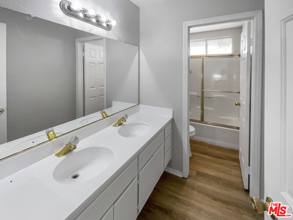 1615 East Kettering Street Lancaster, CA 93535 - Photo 10 of 15 a bathroom with a double vanity sink a mirror and shower