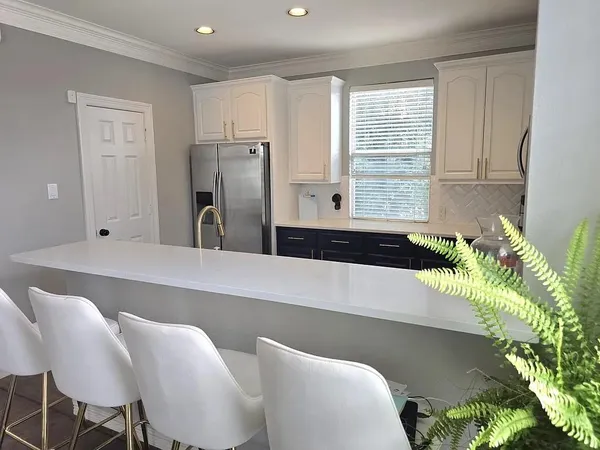 a kitchen with stainless steel appliances a stove a sink island and a refrigerator