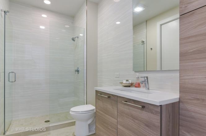 1132 West Adams Street, Unit PHE Chicago, IL 60607 - Photo 14 of 23 a bathroom with a shower sink vanity and toilet