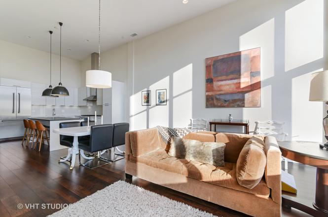 1132 West Adams Street, Unit PHE Chicago, IL 60607 - Photo 5 of 23 a living room with furniture a wooden floor and a chandelier