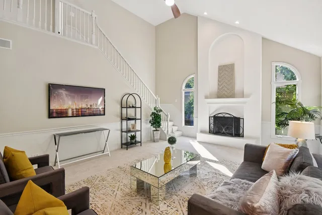 a living room with furniture a fireplace and a floor to ceiling window