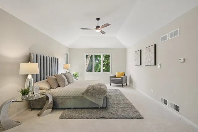 a spacious bedroom with a bed and a chandelier
