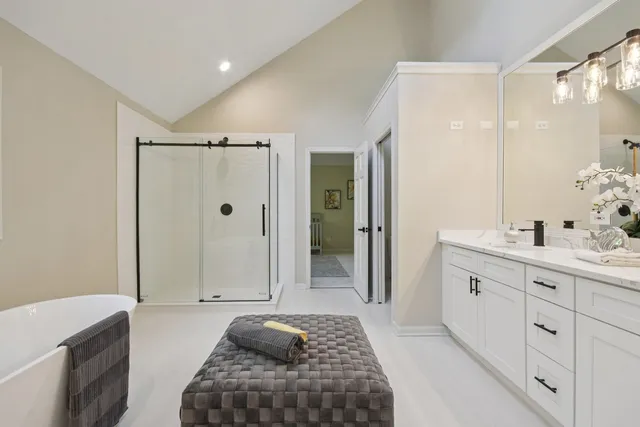 a spacious bathroom with a shower a sink and a mirror