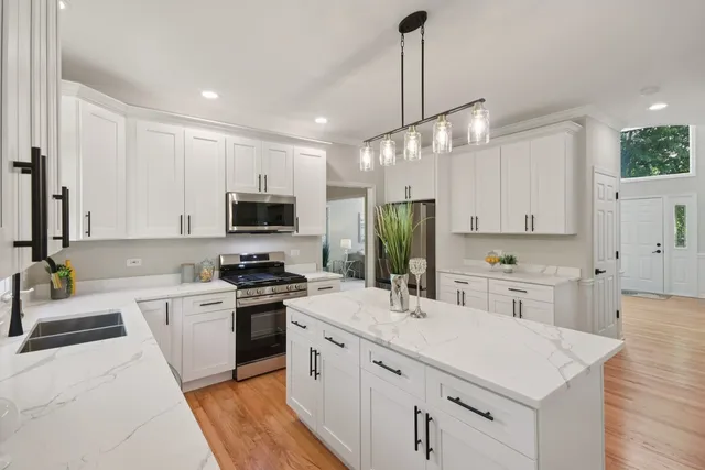a kitchen with a sink stainless steel appliances and white cabinets