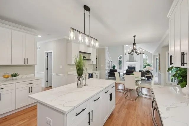 a view of a kitchen counter space a sink wooden floor and living room view