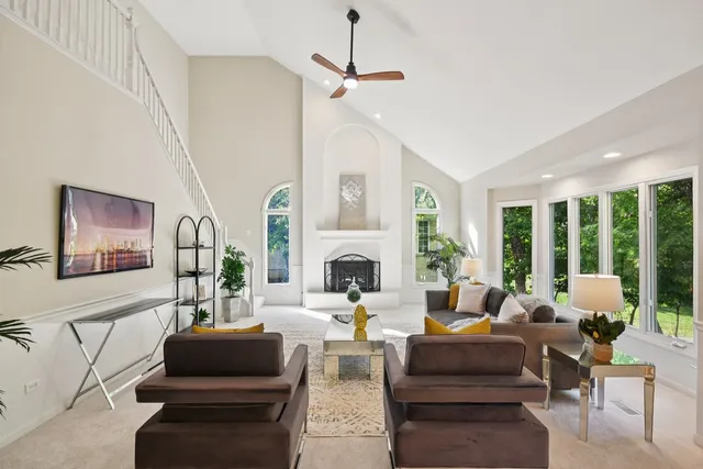 a living room with furniture a large window and a fireplace