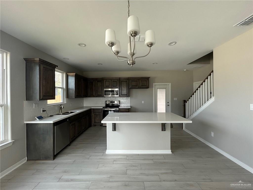 3524 Emory Avenue McAllen, TX 78504 - Photo 5 of 11 a view of living room with stainless steel appliances granite countertop couches a flat screen tv and kitchen view
