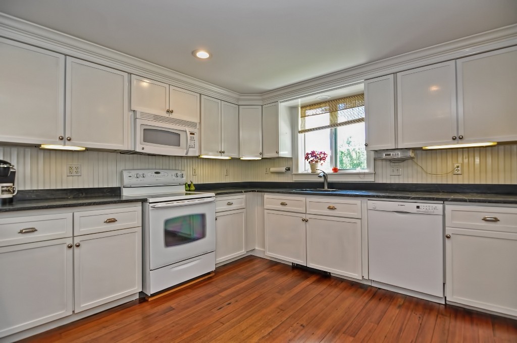 73 Frankland Road Ashland, MA 01721 - Photo 16 of 30 a kitchen with granite countertop white cabinets white appliances a sink and dishwasher with wooden floor