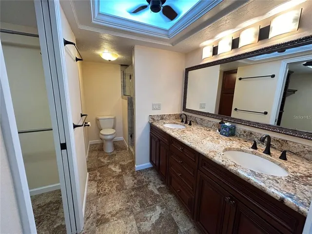 a bathroom with a granite countertop sink toilet and shower