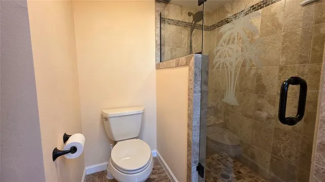 a white toilet sitting next to a shower