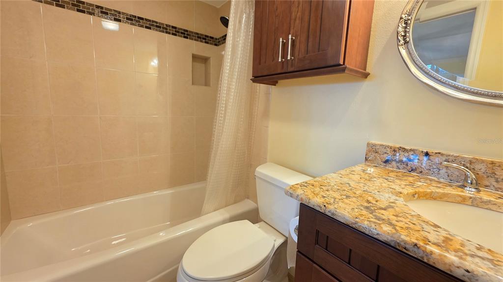 9604 Cortez Road West, Unit 213 Bradenton, FL 34210 - Photo 27 of 36 a bathroom with a granite countertop toilet sink and mirror