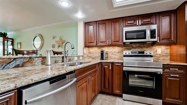 a kitchen with granite countertop a stove microwave and sink