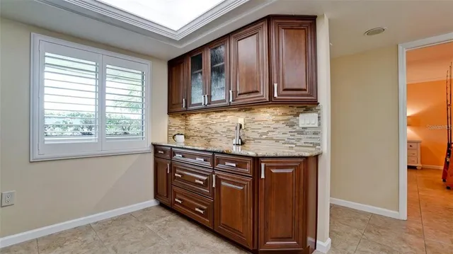 a view of kitchen with granite countertop cabinets and window