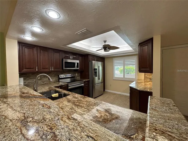 a kitchen with granite countertop a stove and a refrigerator