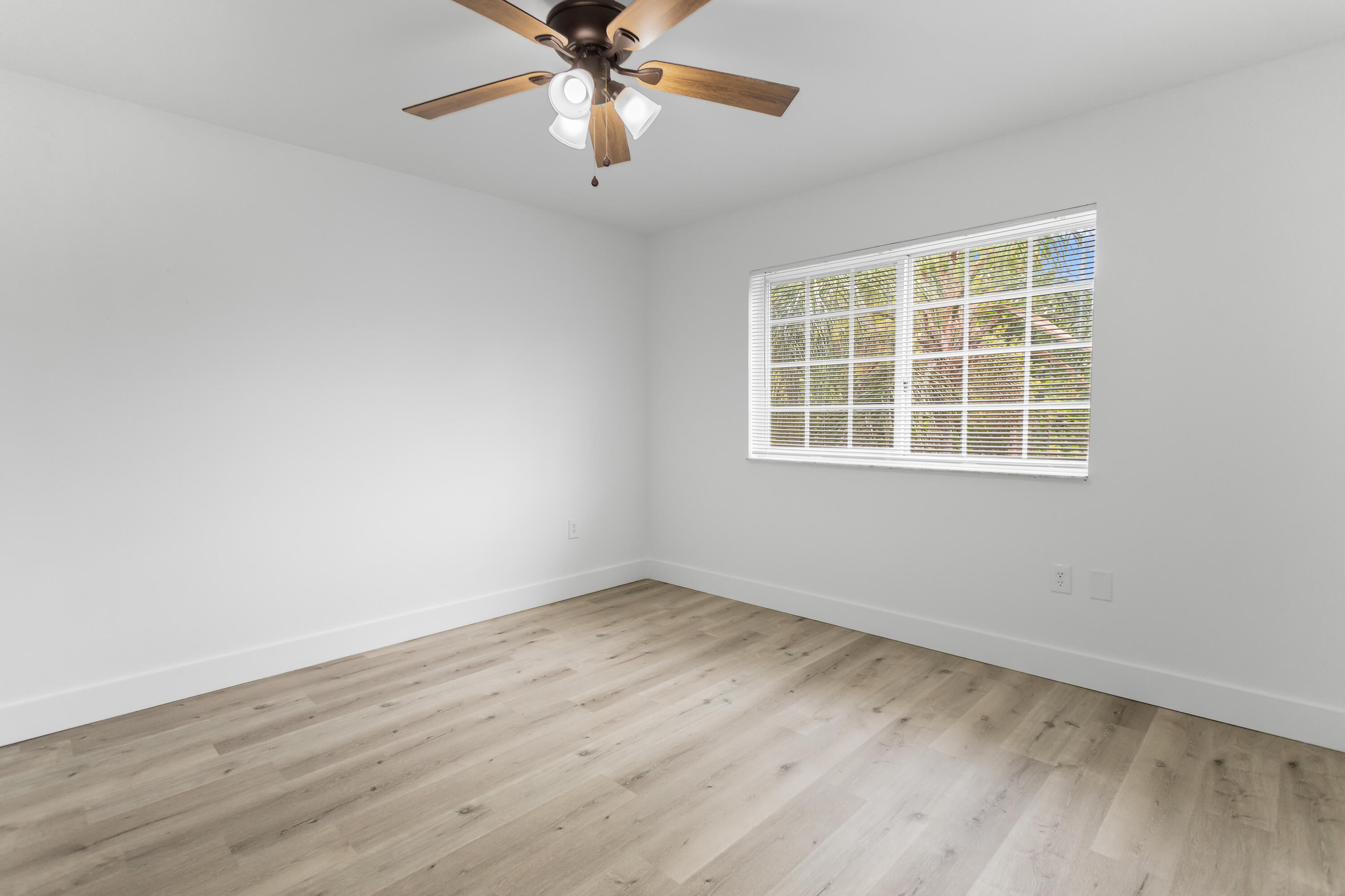 2113 Renaissance Boulevard, Unit 306 Miramar, FL 33025 - Photo 27 of 59 an empty room with wooden floor fan and windows
