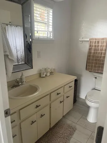 a bathroom with a double vanity sink toilet and a mirror