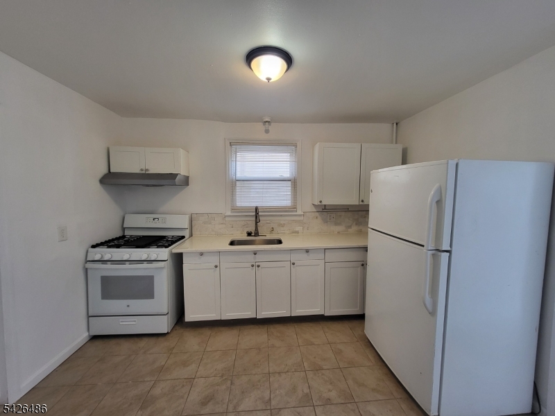 111 Pine Street Elizabeth Port, NJ 07206 - Photo 2 of 9 a kitchen with white cabinets and white appliances