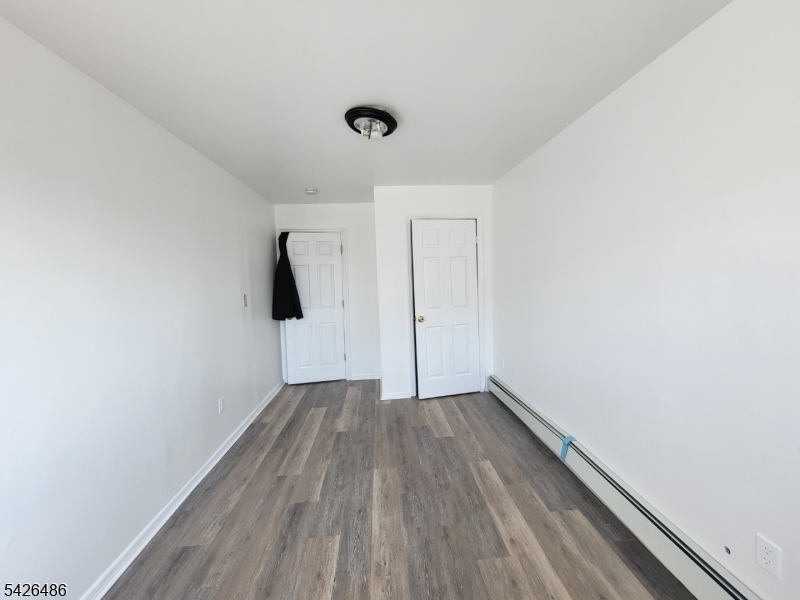 111 Pine Street Elizabeth Port, NJ 07206 - Photo 5 of 9 a view of an empty room with wooden floor and a window