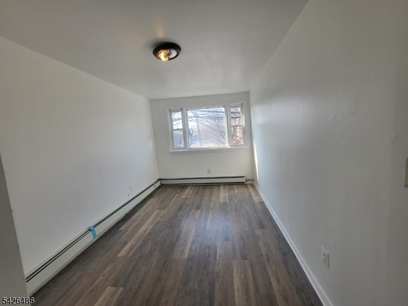 111 Pine Street Elizabeth Port, NJ 07206 - Photo 6 of 9 an empty room with wooden floor and windows