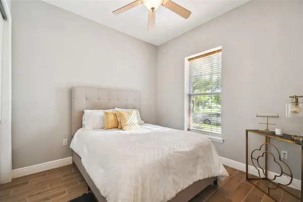 a view of a patio with table and chairs potted plants and floor to ceiling window