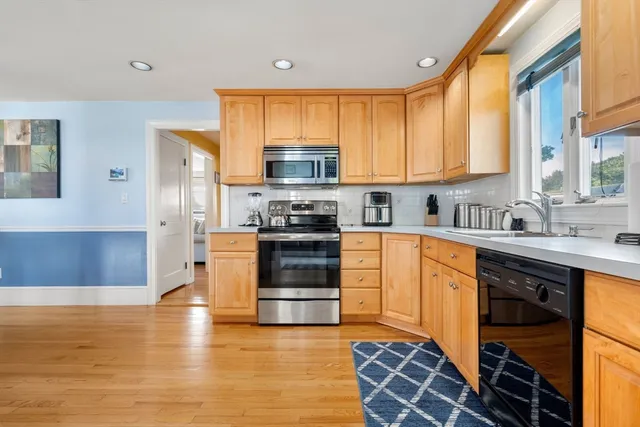 a kitchen with stainless steel appliances granite countertop a stove a sink and a refrigerator
