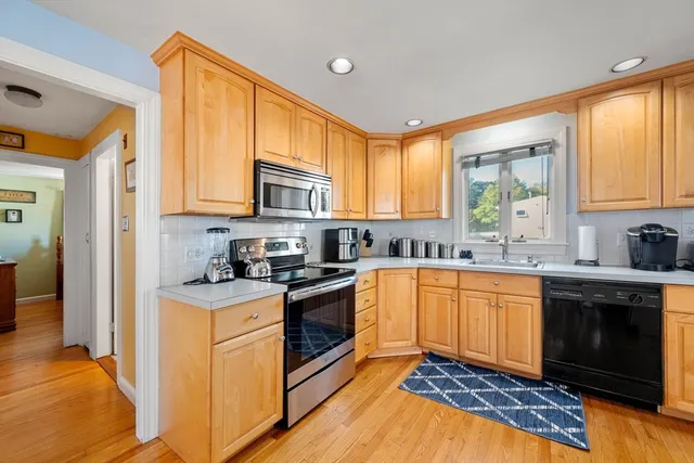 a kitchen with stainless steel appliances granite countertop a stove a sink and a microwave