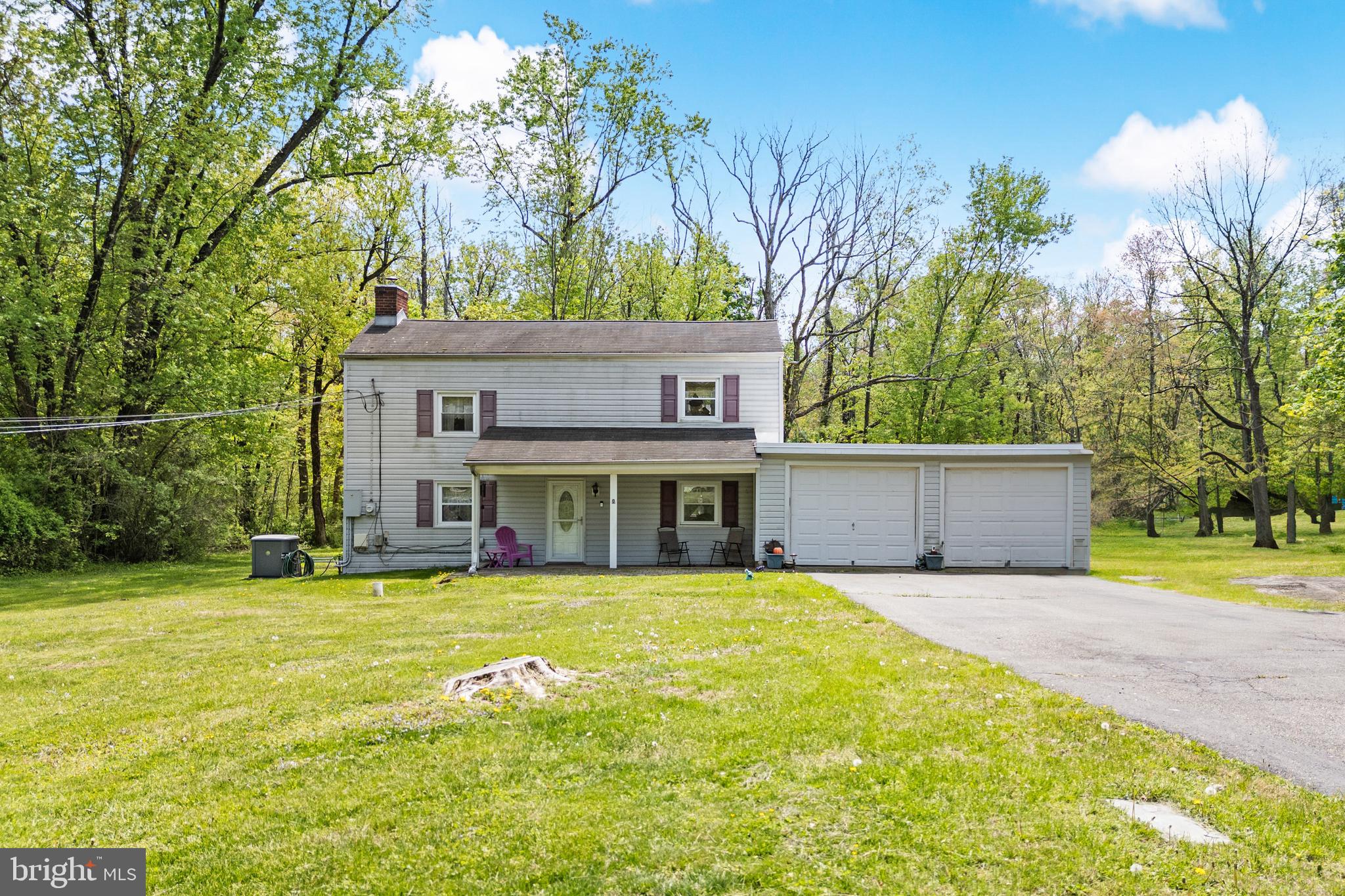 a view of a house with a yard and a large tree