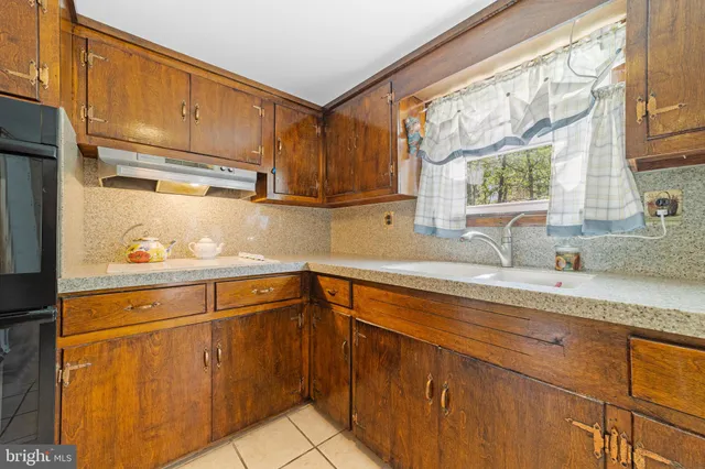 a kitchen with stainless steel appliances granite countertop a sink window and cabinets