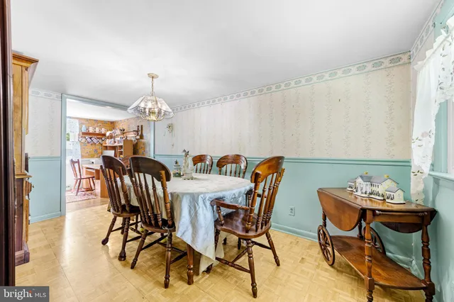 a view of a dining room with furniture a chandelier and wooden floor