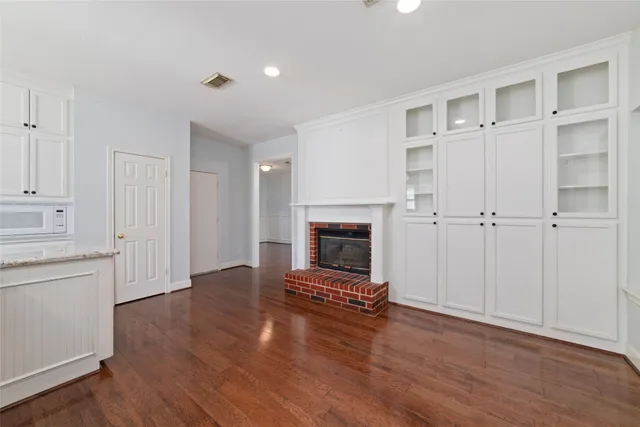 a view of a livingroom with a fireplace wooden floor and windows