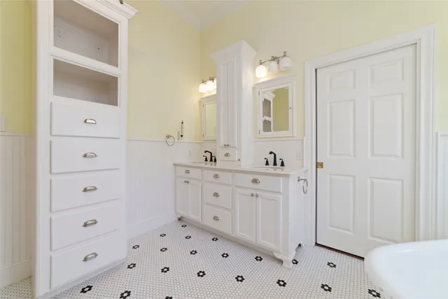 a spacious bathroom with a double vanity sink a mirror and a bathtub