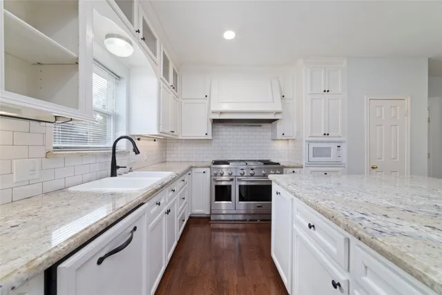 a kitchen with stainless steel appliances granite countertop a sink stove and cabinets
