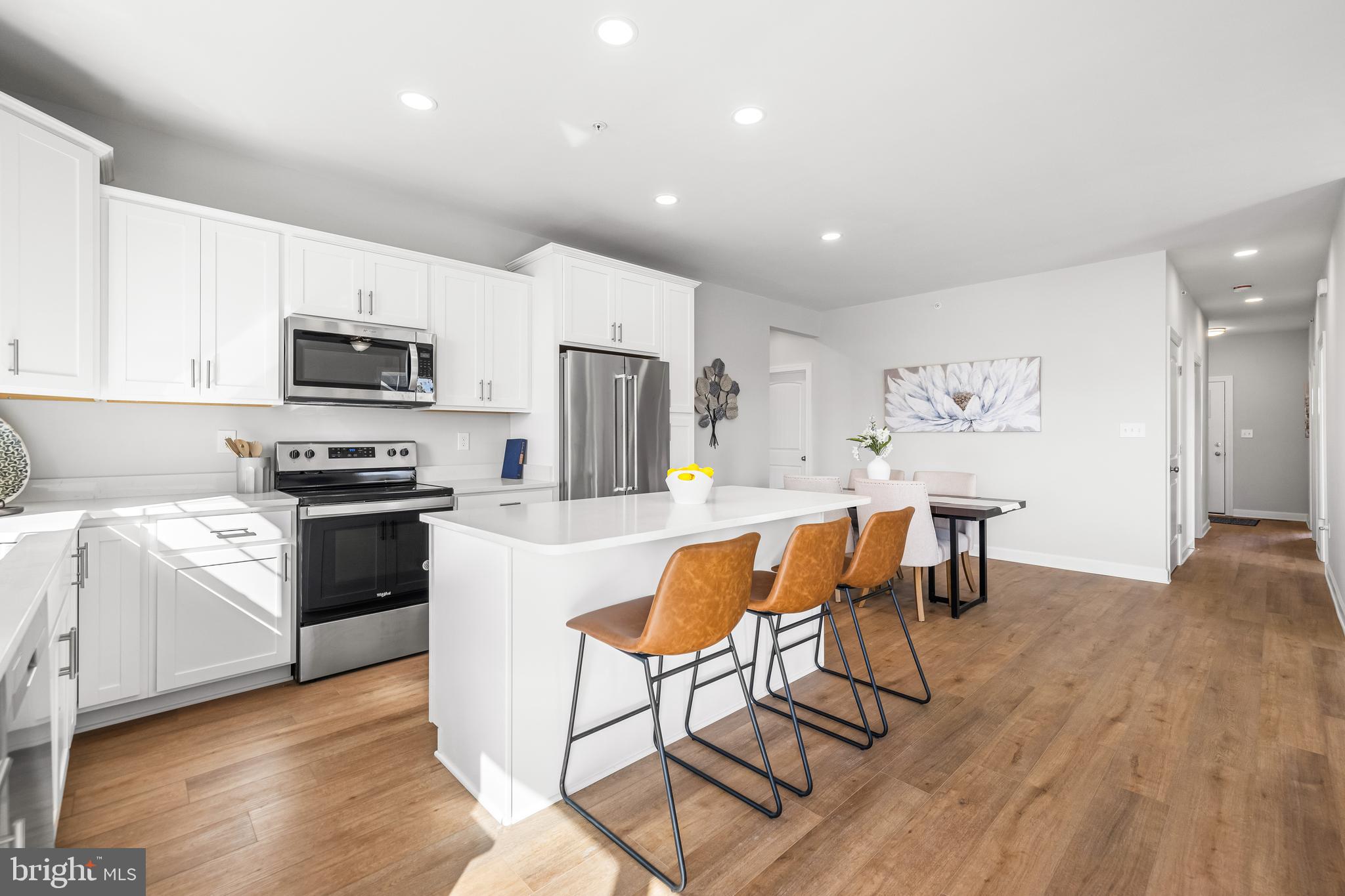 212 Ridgeview Lane, Unit 30 Hanover, PA 17331 - Photo 23 of 39 a kitchen with stainless steel appliances granite countertop a stove a sink a microwave a refrigerator white cabinets and chairs with wooden floor