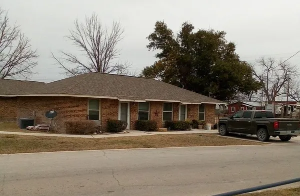 a front view of a house with a garden and parking