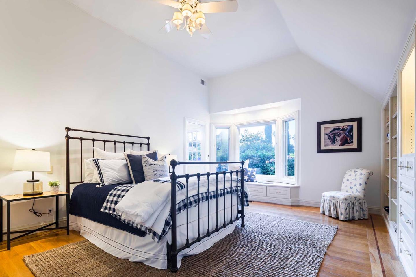 11491 Old Ranch Road Los Altos Hills, CA 94024 - Photo 23 of 52 a bedroom with a large bed and a chandelier