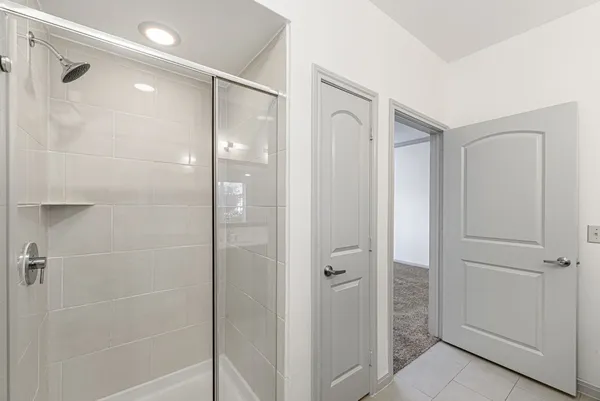 a bathroom with a shower and a glass door