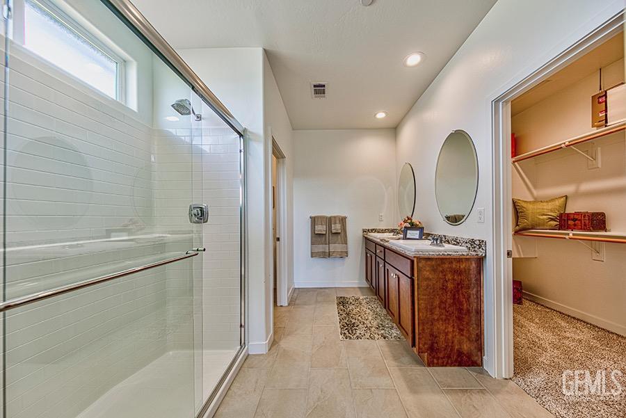 Undisclosed Address Bakersfield, CA 93311 - Photo 5 of 11 a spacious bathroom with a granite countertop sink mirror and shower