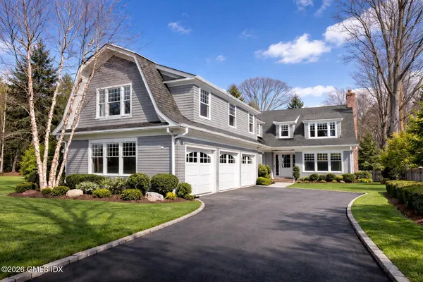a front view of a house with a yard and trees