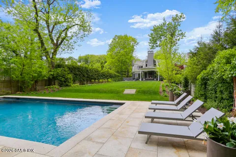a view of backyard with swimming pool and patio