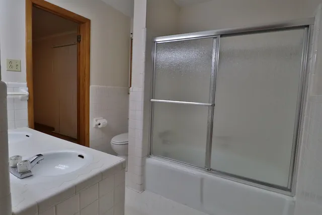 a white toilet sitting next to a shower