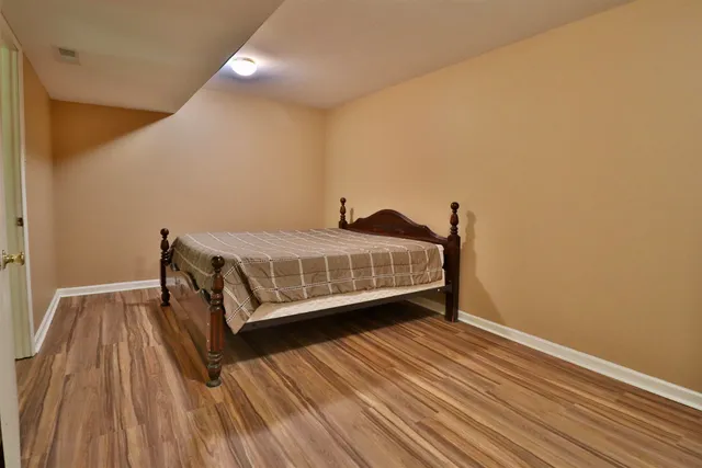 a bedroom with a bed and wooden floor
