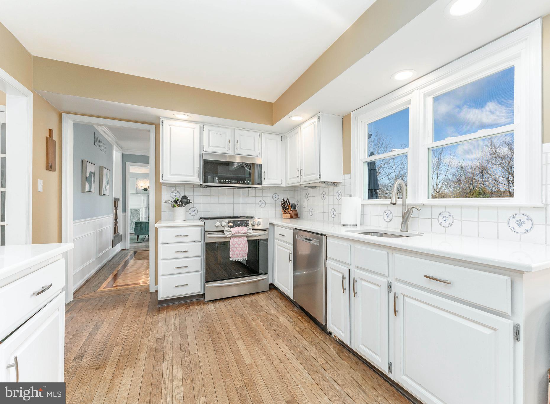 8 Matthews Run Road Chester Springs, PA 19425 - Photo 19 of 80 a kitchen with stainless steel appliances a stove top oven a sink dishwasher and a refrigerator with wooden floor