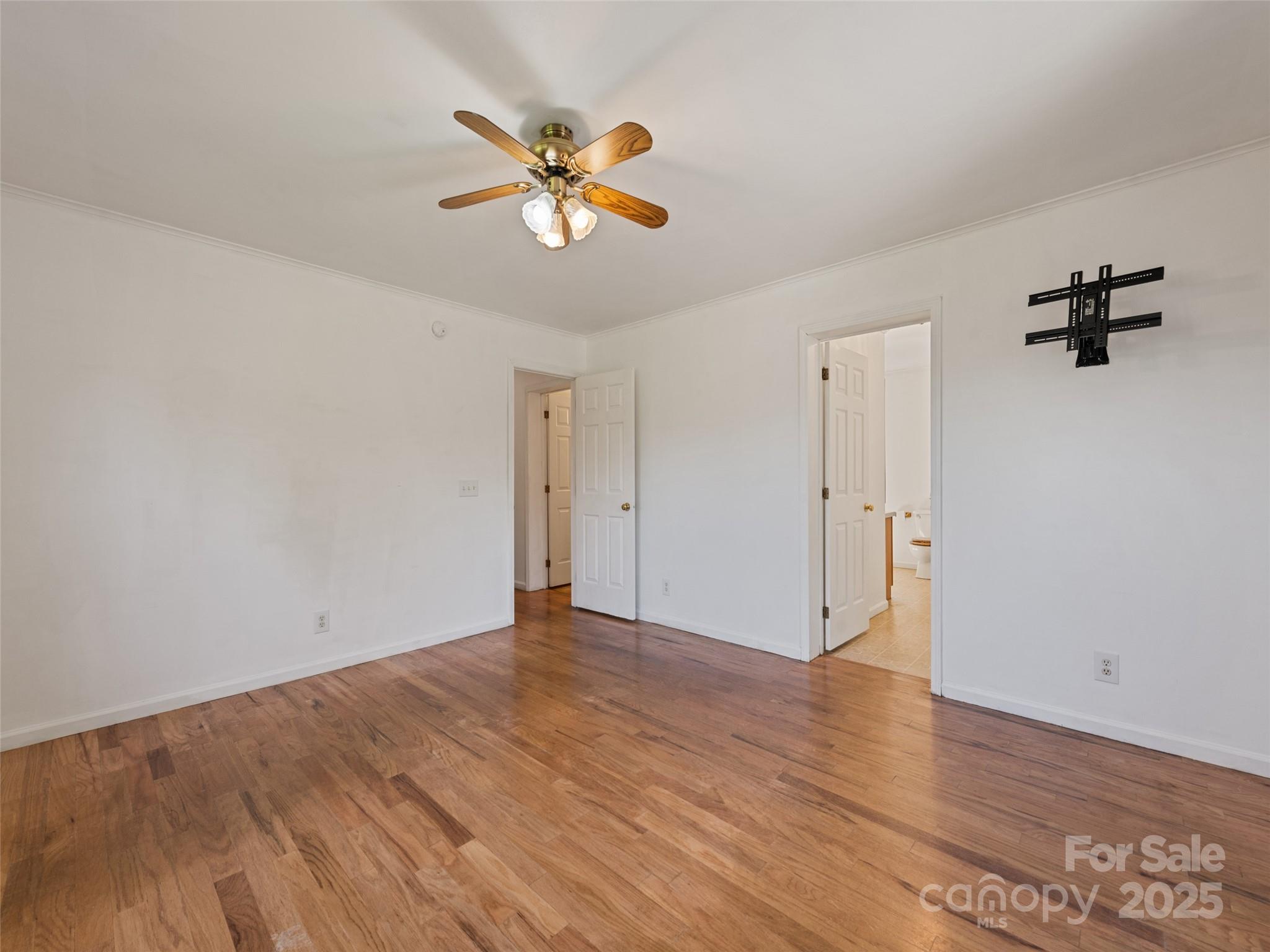 2884 Thickety Road Clyde, NC 28721 - Photo 14 of 20 a view of an empty room with wooden floor and a ceiling fan