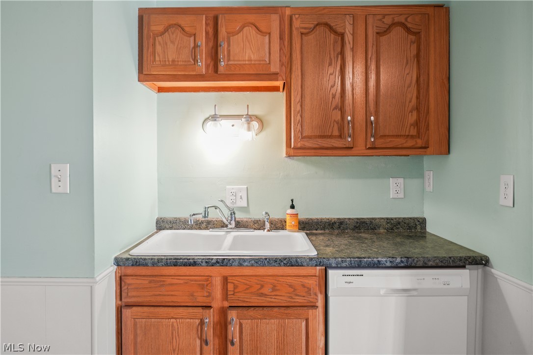 3796 North Santom Road Stow, OH 44224 - Photo 8 of 30 Kitchen area featuring a double basin sink, wood-finish cabinetry, a white dishwasher, and a speckled countertop
