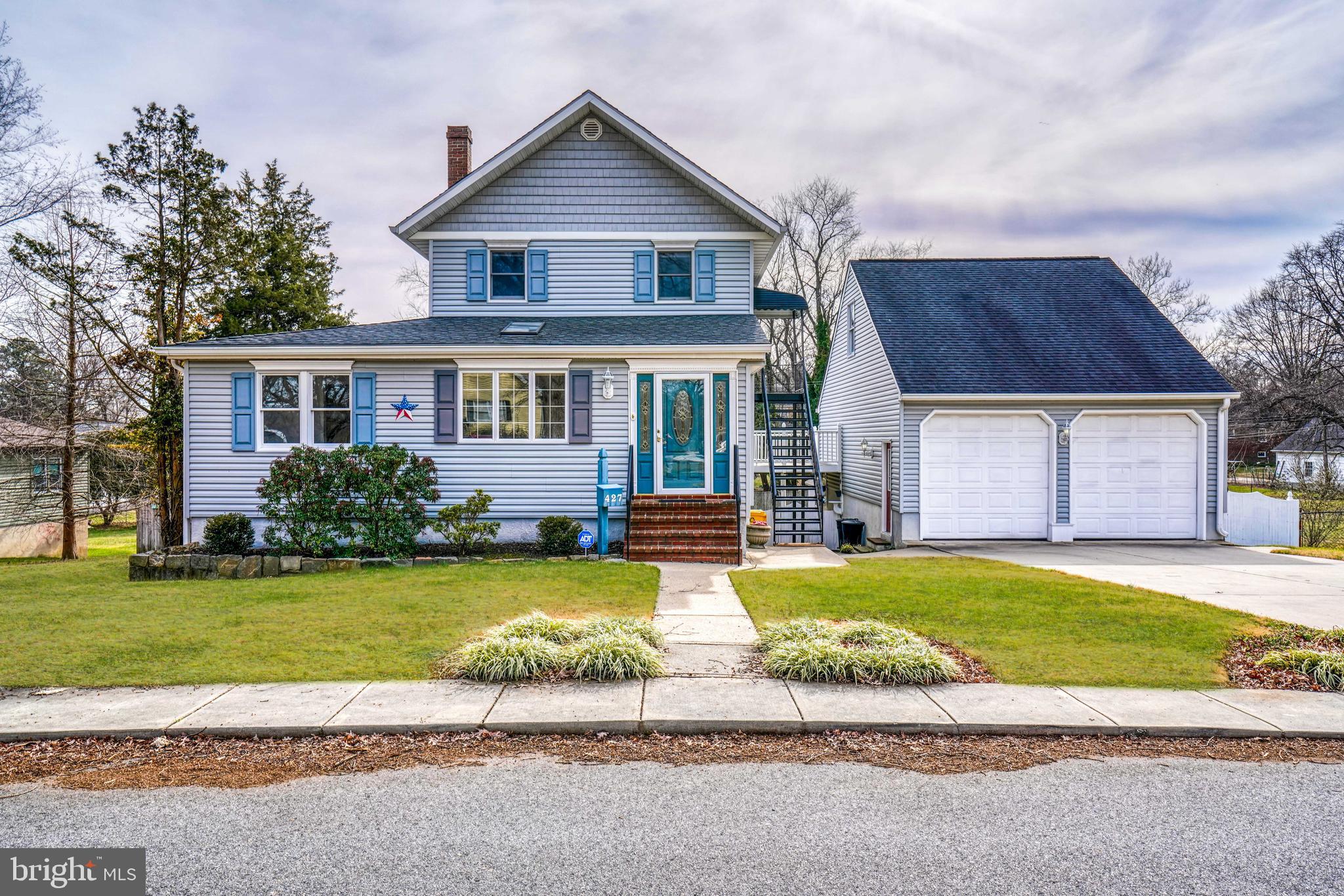 a view of a house with a swimming pool and a yard with trees