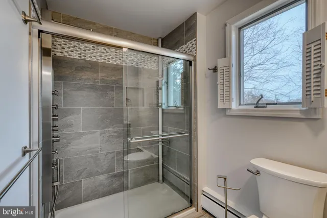 a bathroom with a toilet a sink and mirror