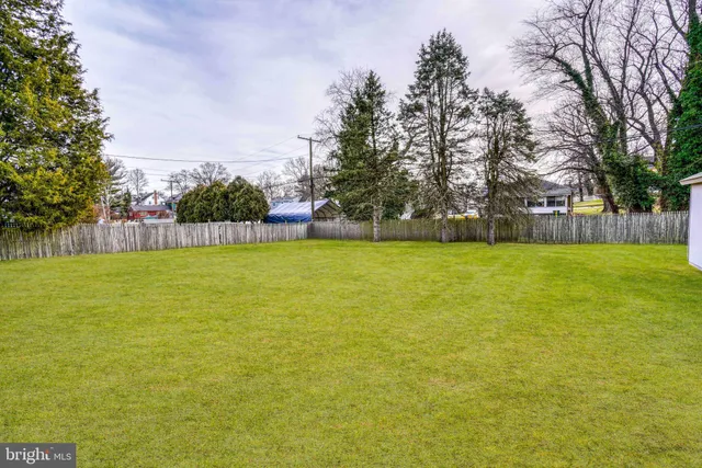 a view of a big house with a big yard and large trees