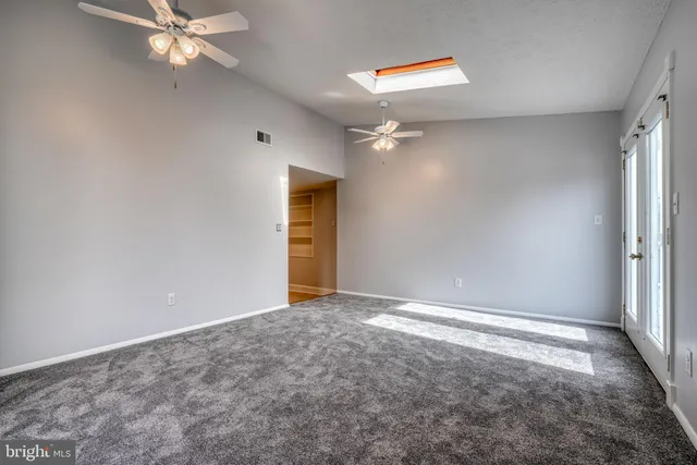 en empty room with window and ceiling fan
