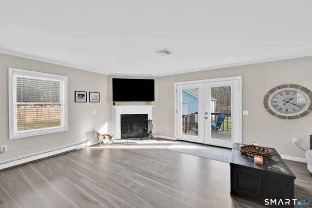 a view of an empty room with window and wooden floor