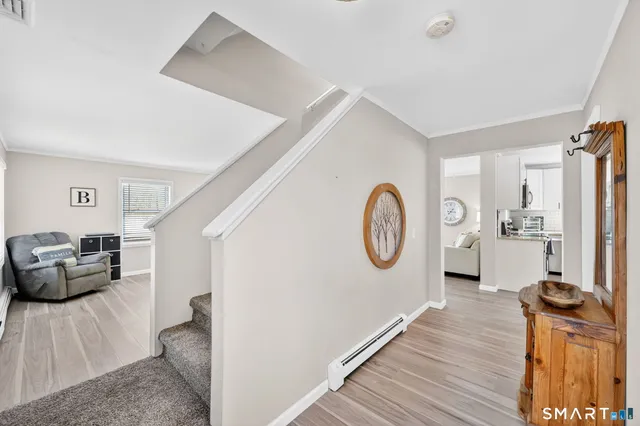 a living room with furniture a clock and wooden floor